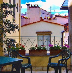 Duas cadeiras e uma mesa em frente a uma varanda em Hotel Esperanza em Florença