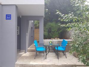 a patio with a table and blue chairs at VIGO apartman in Pula
