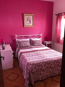 エリセイラにあるLighthouse by the beachのピンクの壁のベッドルーム1室