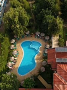 eine Luftansicht auf einen Pool mit Sonnenschirmen und Stühlen in der Unterkunft Hotel Liani - All Inclusive in Sonnenstrand