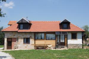 una pequeña casa de piedra con techo rojo en Guest House Glogovac en Kamenica