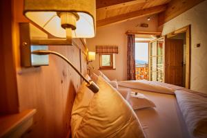 um quarto com duas camas e um candeeiro na parede em Wallegg Lodge - Alpine Premium Chalet - Ski In-Ski Out - Real Alpine Location Saalbach em Saalbach-Hinterglemm