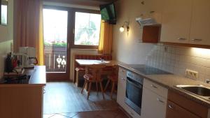 una cucina con lavandino e tavolo con finestra di Doadlerhof a Neustift im Stubaital
