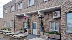 ein Backsteingebäude mit Tischen und Stühlen davor in der Unterkunft Belrom Hotel in Sint-Truiden