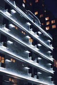 een gebouw met lichten aan de zijkant 's nachts bij Nana City Hotel in Bangkok