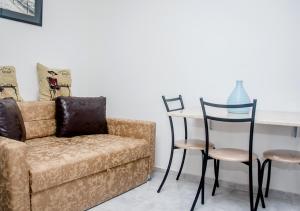 a living room with a couch and a table and chairs at Marina Home in Tbilisi City