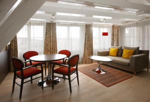 a living room with a couch and a table and chairs at Krasnapolsky Apartments in Amsterdam