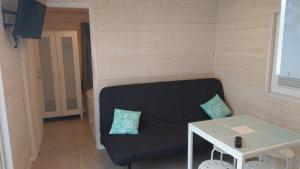 ein kleines Wohnzimmer mit einem Sofa und einem Tisch in der Unterkunft Kamień Bałtyku Rowy in Rowy