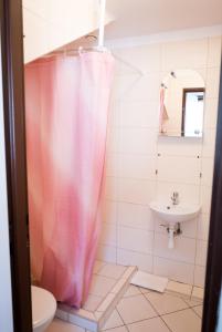 a bathroom with a pink shower curtain and a sink at Baltic in Łeba +47 photos