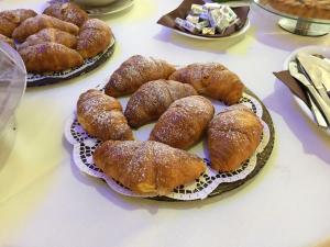 una mesa con tres platos de bollería y pan en Zaiera Resort Siracusa, en Solarino