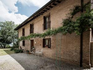 ein Backsteingebäude mit Stühlen und einem Tisch davor in der Unterkunft Accademia al Colle in Bologna