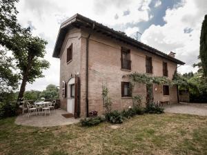 an old brick house with a patio and a table at Accademia al Colle in Bologna