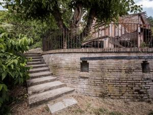 a brick retaining wall with stairs and a balcony at Accademia al Colle in Bologna