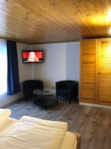 Schlafzimmer mit einem Bett und einem Tisch mit Stühlen in der Unterkunft Hotel Restaurant Simplon in Frutigen