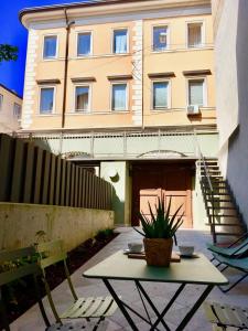 uma mesa com um vaso de plantas em frente a um edifício em Madonna del Mare em Trieste