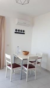 a white dining room table with chairs and a bowl on it at AD in Capo dʼOrlando