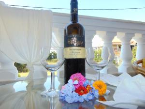 a bottle of wine and two glasses on a table at Hotel Fotini in Mytikas