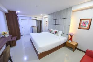 a bedroom with a large white bed in a room at Wish Hotel Ubon in Ubon Ratchathani