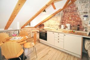 a kitchen with a table and chairs and a brick wall at Seafront Apartment 2 in Cavtat