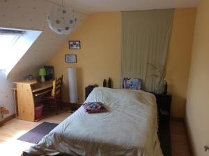 a bedroom with a bed and a desk in a attic at aux 2 oies in Plouider
