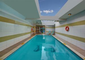 una piscina in un edificio con soffitto di Sharjah Palace Hotel a Sharjah