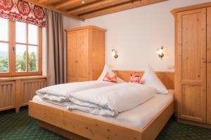 フィスにあるHaus Raschlguatの白いシーツが敷かれた木製ベッドのある寝室