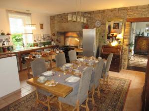Un comedor con una mesa y una cocina. en Le Vieux Couvent & SPA, en Sibiril