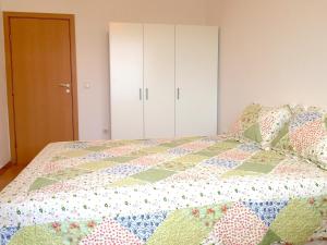 a bedroom with a bed with a quilt on it at El MATE apartment Sea Garden and Beach Varna in Varna City