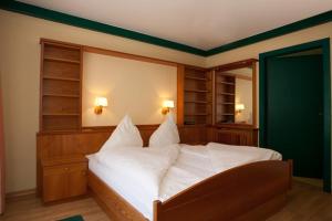 a bedroom with a large bed with white pillows at Ferienwohnungen Kärnten Dr. Baumgartner in Faak am See