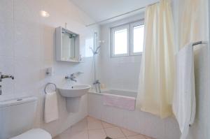 a bathroom with a sink and a toilet and a tub at Villa White Dove in Golden Sands
