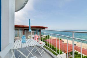 a balcony with a bench and the beach at Villa White Dove in Golden Sands