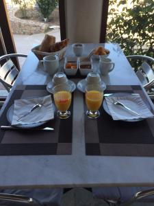 - une table avec un petit-déjeuner composé de jus d'orange et de pain dans l'établissement U Filipaghju, à Galéria
