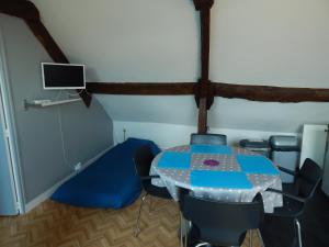 a room with a table and chairs and a tv at Au cœur du centre historique in Bayeux