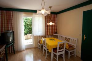 a dining room with a yellow table and chairs at Ferienwohnungen Kärnten Dr. Baumgartner in Faak am See
