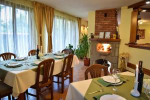 ein Esszimmer mit zwei Tischen und einem Kamin in der Unterkunft Lina Hotel in Bansko