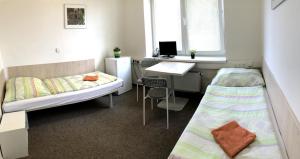 Habitación con 2 camas y escritorio con ordenador. en MiniPenzion Na Vyhlídce en Olomouc