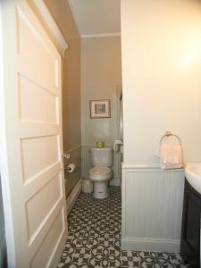a bathroom with a toilet and a sink and a door at Bellevue House in Newport