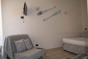 a room with a bed and a chair and a tv at carugio del fezzano in Fezzano