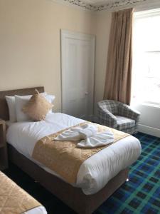 a bedroom with a bed with towels on it at Royal Guest House Nairn in Nairn