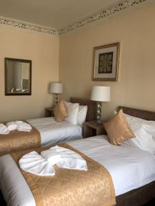 a hotel room with two beds and a mirror at Royal Guest House Nairn in Nairn