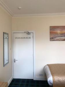 a room with a bed and a door at Royal Guest House Nairn in Nairn