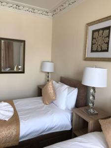 a hotel room with two beds and a mirror at Royal Guest House Nairn in Nairn