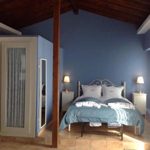 a blue bedroom with a bed and two lamps at Metochi in Taxiarchis