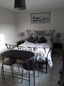1 dormitorio con 1 cama con mesa y sillas en Foxholes Accommodation en Bristol