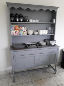 a kitchen with a shelf full of food at Foxholes Accommodation in Bristol