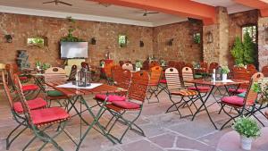 ein Restaurant mit Tischen und Stühlen sowie einem TV in der Unterkunft Das Lamm Heidelberg in Heidelberg