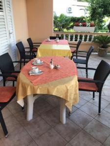 una mesa con un mantel amarillo y rojo. en Guest House Sandra, en Rab