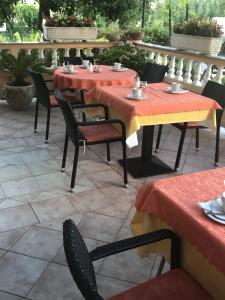 dos mesas y sillas con mantel rojo y amarillo en Guest House Sandra, en Rab