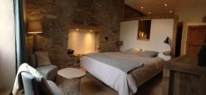 A bed or beds in a room at Le Val d'Ailleurs