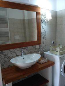 uma casa de banho com um lavatório, um espelho e uma máquina de lavar roupa em Umbria vista lago Trasimeno em Castel Rigone